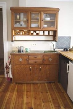 a kitchen with wooden floors and cabinets