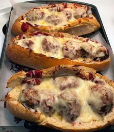 three breads with meatballs and cheese on them sitting in a baking pan, ready to be baked