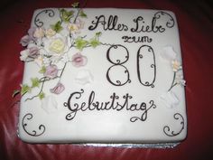 a sheet cake decorated with flowers and the words 80 gebulthauss on it