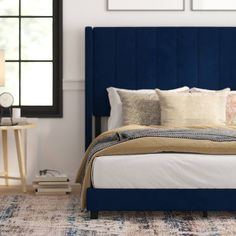 a bed with blue headboard and pillows in a room