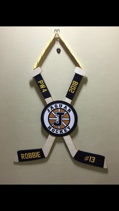 an ice hockey logo hanging on the wall with two sticks attached to it's sides