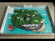 there is a cake made to look like a boat in the water with green algae on it