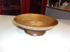 a wooden bowl sitting on top of a white table