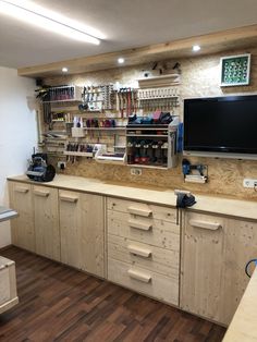 a kitchen with wooden cabinets and a flat screen tv