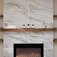 a fireplace in a living room with white marble walls