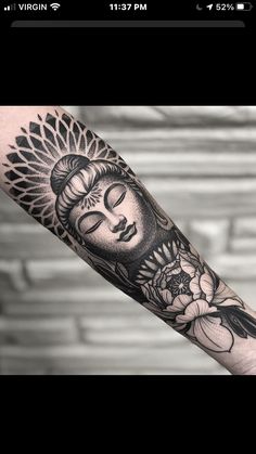 a woman's arm with a buddha tattoo on it