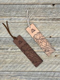 two wooden tags with floral designs on them