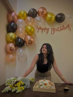 a woman sitting at a table in front of a birthday cake