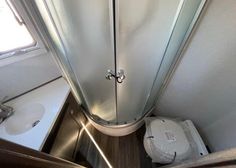 the inside of a bathroom with a shower and toilet in it, next to a sink