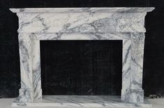 a white marble fireplace with black background