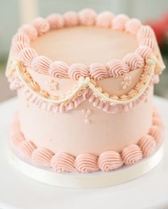 a cake with pink icing and ruffles on top