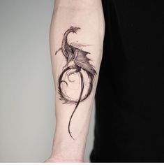 a man's arm with a bird tattoo on it