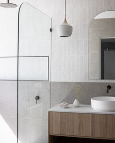 a bathroom with a sink, mirror and shower