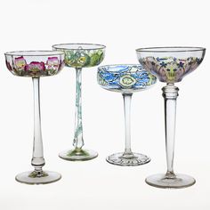 four glass goblets with different designs on them