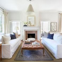 a living room filled with furniture and a fire place in the middle of a room