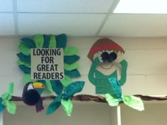 some paper cutouts are hanging on the wall next to a sign that says looking for great readers