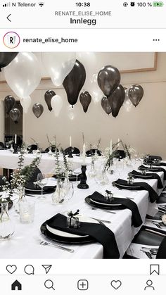 the table is set with black and white tables cloths, silver balloons, and greenery