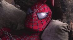 a spiderman stuffed animal sitting on top of pillows