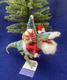 a toy dinosaur with a christmas tree on its back