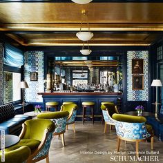 the interior of a restaurant with blue and green chairs, gold trimmings on the bar