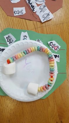 a paper plate with marshmallows on it next to some cut out stickers