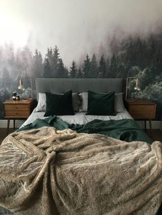 a bedroom with a bed, nightstands and wallpaper that has trees on it