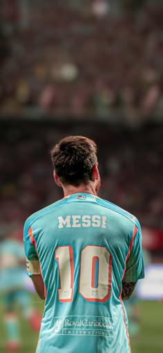 a man standing on top of a soccer field wearing a blue uniform with the number 10 on it