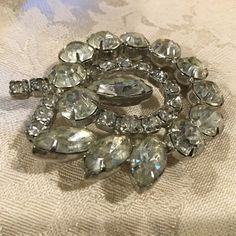 "Gorgeous Glitzy vintage 1950s clear Rhinestone Brooch featuring a designer quality crafted swirled design ....Hand prong set Sparkling large Marquis & Round Stones- smaller swirl of round stones took pics with different backgrounds & lighting to try & catch the sparkle of the pin. Measurements: 2\" x 1 7/8\" Great condition with all stones in place, all clear & sparkling and silver tone metal...roll over safety closure." Clear Crystal Necklace, Round Bead Necklace, Gold Leaf Earrings, Crystal Bead Necklace, Gold Bead Bracelets, Swirl Design, Statement Bracelet, Rhinestone Jewelry, Rhinestone Brooches