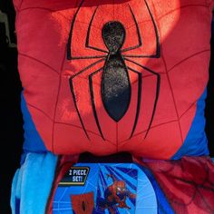 a spiderman pillow sitting on top of two other pillows