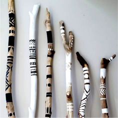 four different types of sticks are lined up on the wall, and one is made out of driftwood