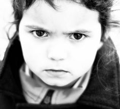 a black and white photo of a young boy with curly hair looking at the camera