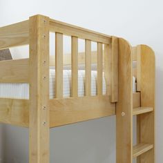 a wooden bunk bed sitting next to a white wall