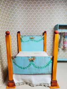 a dollhouse bed made out of an old wooden frame and painted blue with flowers