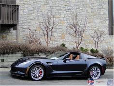 a black sports car parked in front of a brick building