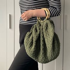 a woman holding a green purse in her hand