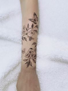 a woman's foot with a tattoo on it and flowers in the middle of her leg