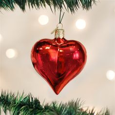 a red heart ornament hanging from a christmas tree