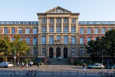 an old building with many windows and people walking around