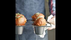 three muffins on a tray being held by a person