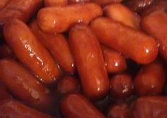 a bowl filled with lots of hotdogs sitting on top of a table