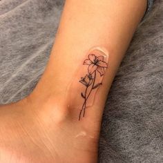 a small flower tattoo on the ankle