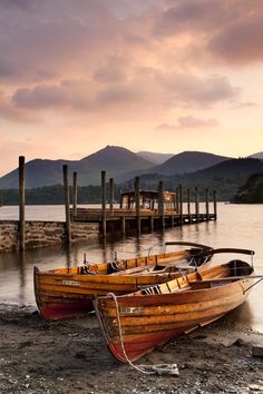 two wooden boats sitting on top of a beach