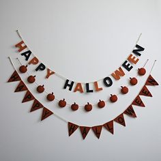 a happy halloween banner hanging on the wall with apples and pumpkins around it that says happy halloween