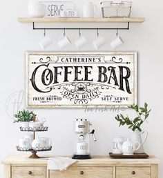 a coffee bar sign hanging on the wall above a wooden table with cups and mugs