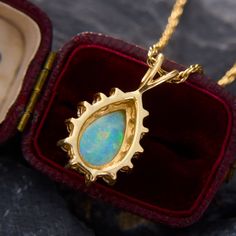 This mesmerizing pendant features a pear cabochon cut opal that is nicely encompassed by a beautiful halo of round brilliant cut diamond accents. The pendant is crafted from 14k yellow gold and hangs from a 24 inch 14k yellow gold rope chain. The opal has some light crazing, but is not very noticeable and does not distract from its great play-of-color. Formal Opal Teardrop Pendant Jewelry, Formal Teardrop Opal Pendant Jewelry, Yellow Gold Teardrop Jewelry With Halo Setting, Yellow Gold Teardrop Halo Jewelry, Gold Pear-shaped Halo Jewelry, Yellow Gold Opal Teardrop Pendant Jewelry, Formal Opal Pear-shaped Jewelry, Pear-shaped Opal Jewelry For Formal Occasions, Formal Pear-shaped Opal Jewelry