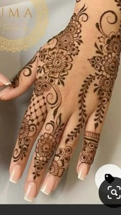 a woman's hand with henna tattoos on it