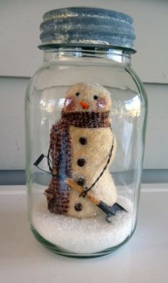 a snowman in a jar with a hat and scarf