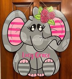 a door hanger with an elephant wearing a flower on it that says lily grace