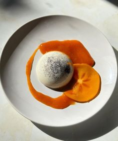 a white plate topped with an orange dessert