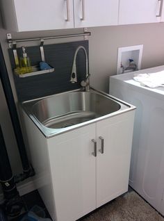 a kitchen with a washer and dryer next to the sink in front of it